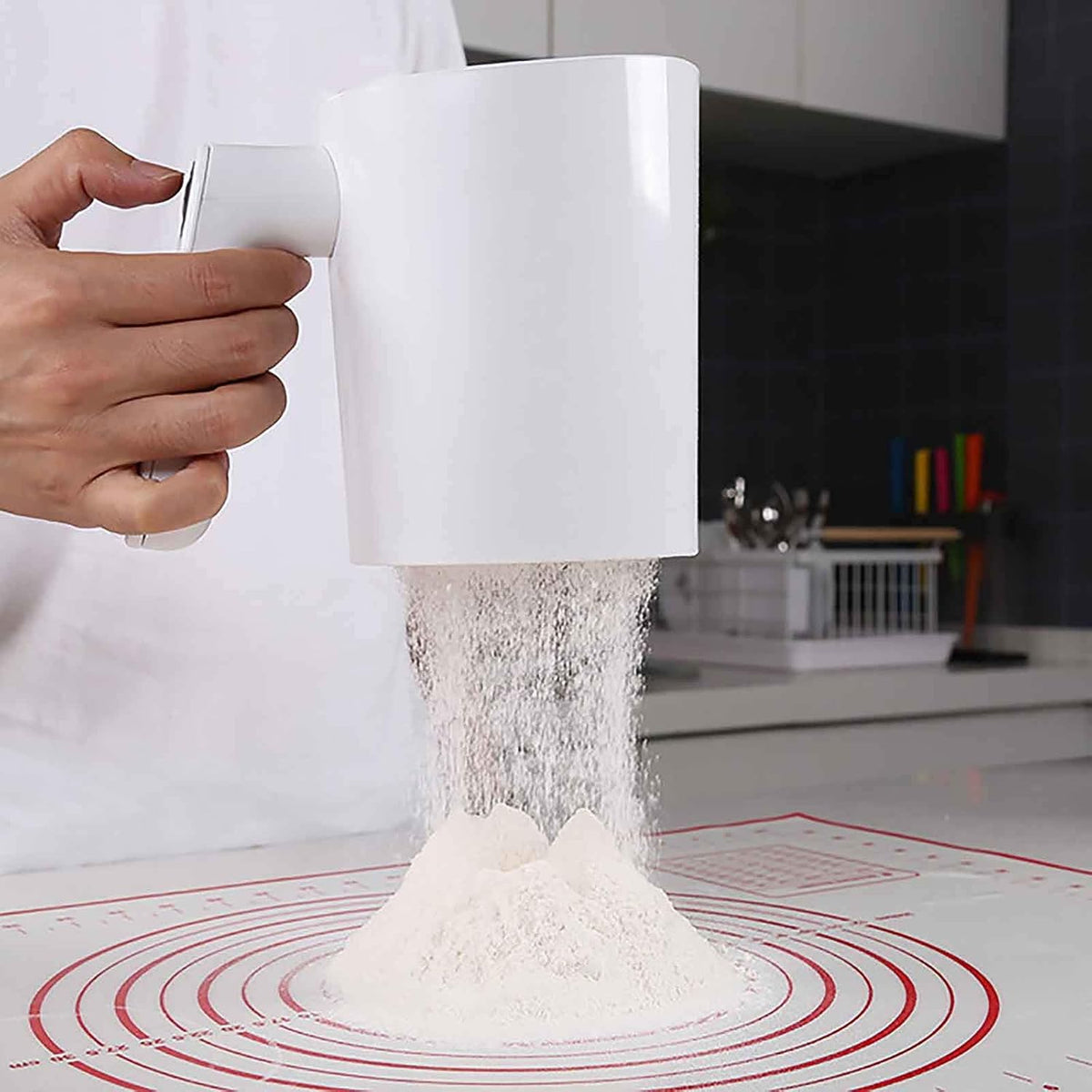 Electric flour sifter showing its handheld squeeze-handle design and 4 cup ingredient container.