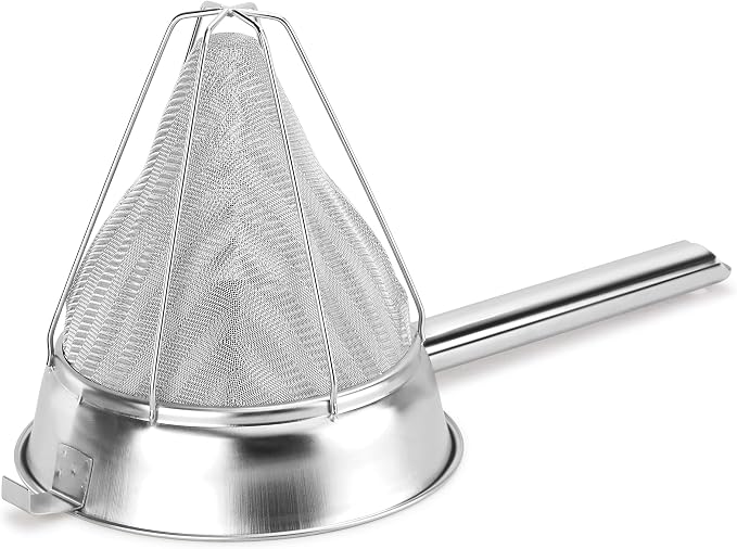 Stainless steel bouillon strainer used to separate food particles from freshly prepared soup.